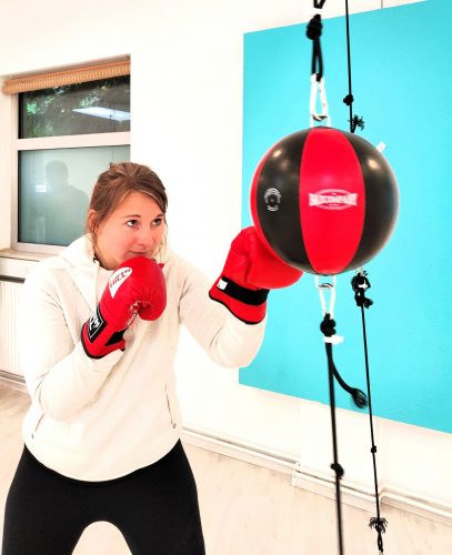 Mirja - therapeutischer Boxcoach - in Aktion mit Boxhandschuhen an einem Doppelendball
